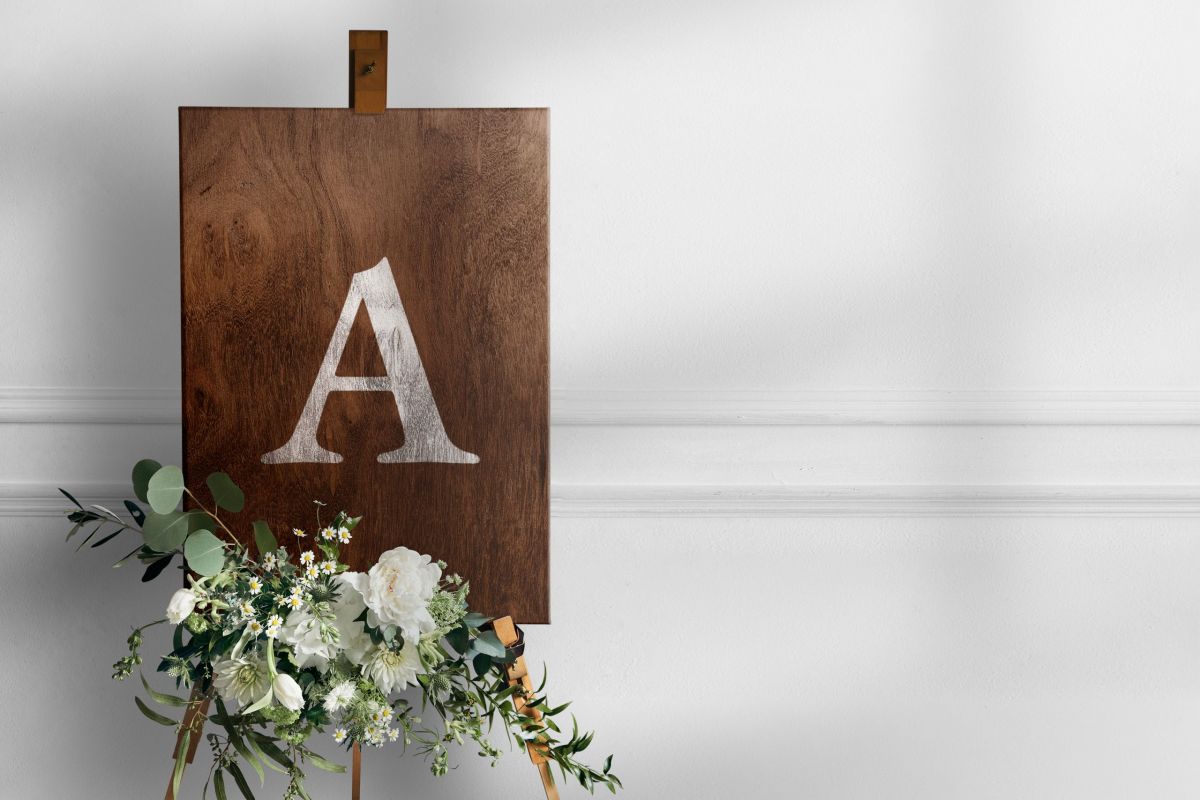 Wedding easel sign mockup psd in wooden texture with flowers